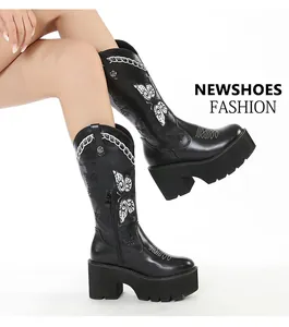Detailed view of black platform Western boots featuring intricate white butterfly embroidery
