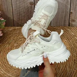 Detailweergave van crème chunky sneakers met ademend mesh en dikke platformzolen