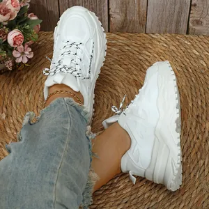 Detail van witte chunky dad-schoenen met ademend mesh en ontwerp met Running-tekstprint.