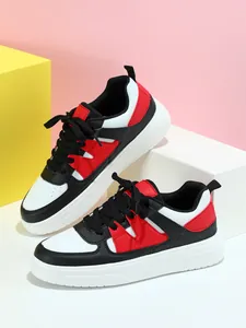 Vista lateral de zapatillas deportivas gruesas en bloques de color negro blanco y rojo