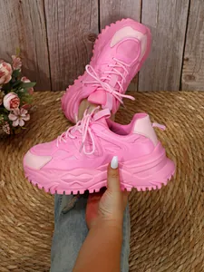 Gedetailleerd overzicht van roze chunky platform sneakers met ademend gaasweefsel