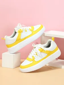 Vista lateral detallada de zapatillas de plataforma modernas en amarillo y blanco