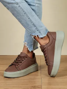 Seitendetail brauner Plateau-Sneaker mit dicker grauer Sohle und heller blauer Jeans
