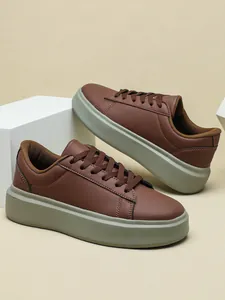Stylische braune Plateau-Sneaker mit dicker olivfarbener Sohle und Schnürdesign