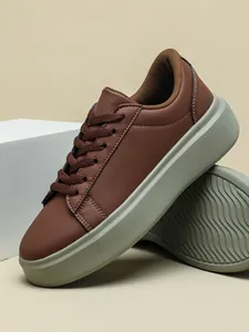 Detailansicht brauner Plateau-Sneaker mit dicker grauer Sohle und Wellenprofil