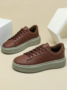 Detaillierte Seitenansicht brauner Plateau-Sneaker mit klobiger grauer Gummisohle