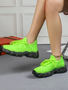 Atmungsaktive neongrüne Fly-knit-Sneaker für Damen mit klobigen schwarzen Sohlen