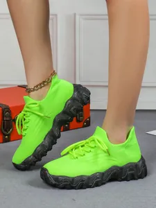 Detailansicht der atmungsaktiven neongrünen Fly-Knit-Socken-Sneaker an den Füßen des Models