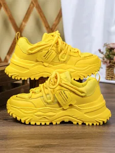 Gedetailleerde weergave van felgele chunky dad-sneakers met ademende mesh-textuur