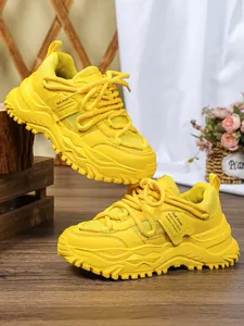 Detailopname van de felgele chunky platform dad sneakers met ademend mesh