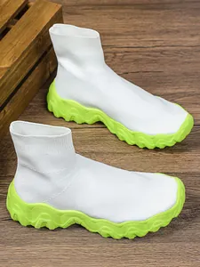 Ademende witte gebreide sok-sneakers met dikke neongroene zolen en platformontwerp