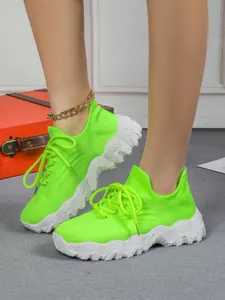Auffällige neongrüne Strick-Socken-Sneaker mit klobigen weißen Struktursohlen.