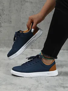 Dettaglio di sneaker platform blu navy con suola bianca e accenti marroni sui tacchi