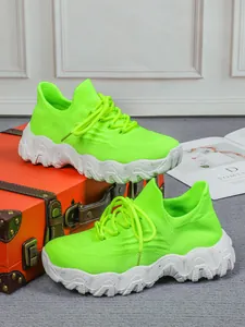 Detailansicht der neongrünen Fly-Knit-Sneaker mit klobigen weiß gesprenkelten Sohlen