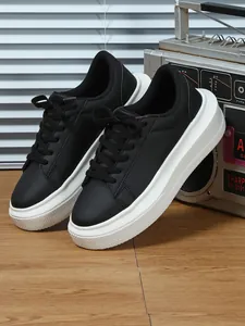Zijaanzicht detail van zwarte dames sneakers met plateauzool, witte zool en een vintage radio