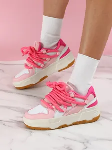 Vista lateral de zapatillas de plataforma rosas y blancas con cordones de cuerda gruesos.