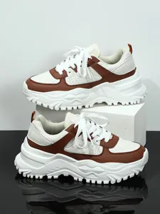 Brown and white chunky platform sneakers on minimalist geometric display blocks
