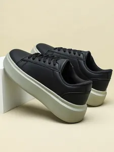 Detailansicht stilvoller schwarzer Low-Top-Sneaker mit dicker beiger Plateausohle