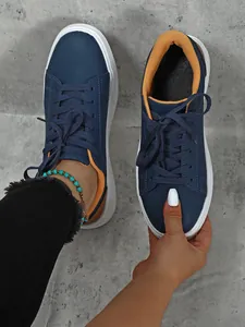 Dettaglio scarpe da skate blu navy con suola platform e fodera interna gialla a contrasto.