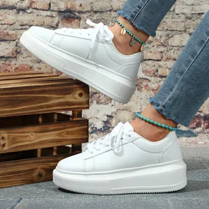 Gedetailleerd zijaanzicht van witte dames sneakers met een modieuze dikke platformzool.