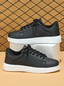 Profilo laterale dettagliato di sneaker casual nere con spesse suole bianche e lacci