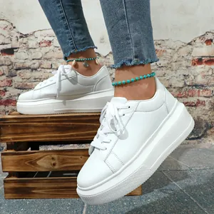 Close-up van witte platform sneakers aan de voet met casual streetstyle achtergrond.