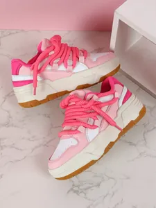 Detalle de zapatillas gruesas rosas y blancas con cordones de cuerda y suela de plataforma.