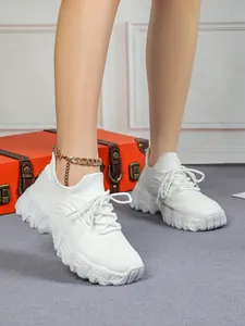 Nahaufnahme von weißen Damen-Stricksneakern mit dicken Plateausohlen am Modell