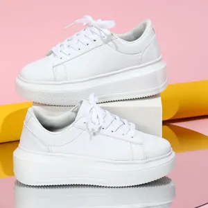 Gedetailleerde zijweergave van witte platform sneakers op roze en gele achtergrond