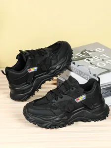 Vista dettagliata di sneakers chunky nere traspiranti con suola spessa ed etichetta