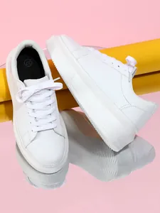 Detailopname van witte dames sneakers met platformzool en vetersluiting op spiegel