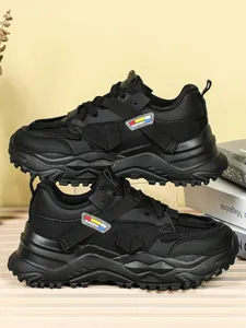 Dettaglio laterale di sneaker chunky nere da donna con mesh e suola molto spessa