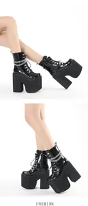 Close-up detail of black patent leather platform boots with silver metal chain decor