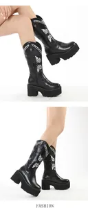 Detail view of women's black platform western boots with white butterfly embroidery