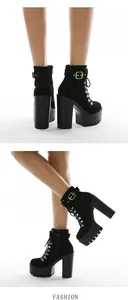 Detailed view of black suede platform boots with chunky high heels and belt buckle accents
