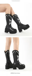 Detailed view of black platform boots with intricate white butterfly embroidery