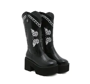 Close-up of vintage black platform western boots with white butterfly embroidery