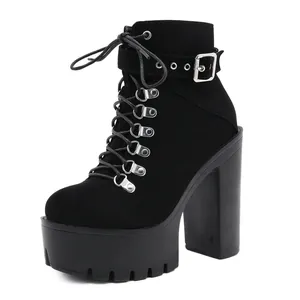 Close-up detail of black platform ankle boots featuring chunky heel and buckle strap