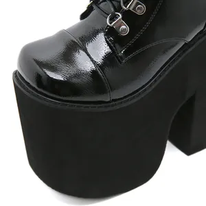 Close-up of black patent leather platform boots with shiny finish and thick sole