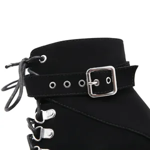 Close-up detail of black suede platform ankle boot featuring silver buckle strap and laces