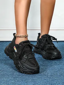 Dettaglio di sneakers nere da donna con zeppa spessa e tomaia in mesh traspirante