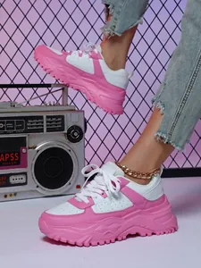 Detailed macro view of trendy pink and white chunky platform dad sneakers for women.