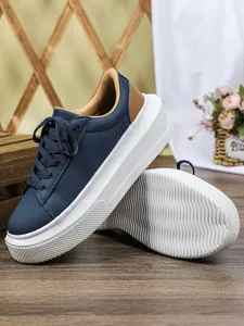 Detailoverzicht van marineblauwe damesplateausneakers met stijlvolle dikke witte zolen