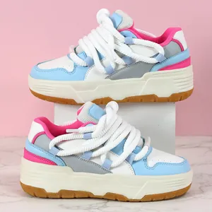 Vista de detalle de zapatillas de plataforma con toques rosas y cordones de cuerda gruesa.
