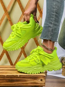 Detailopname van neongroene platform sneakers met ademend mesh en dikke zolen