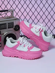 Close-up of pink and white chunky platform sneakers with a retro radio background
