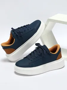 Detailansicht dunkelblauer Plateau-Sneaker mit braunem Futter und weißer Sohle.