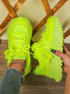 Gedetailleerd overzicht van neongroene chunky platform sneakers met mesh-textuur
