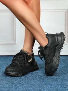 Dettaglio di sneakers nere spesse da donna in mesh traspirante con suola platform dal design moderno