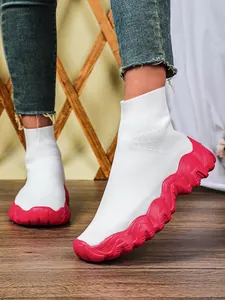 Detail van ademende witte gebreide sneakers met grove fuchsia roze golfzolen